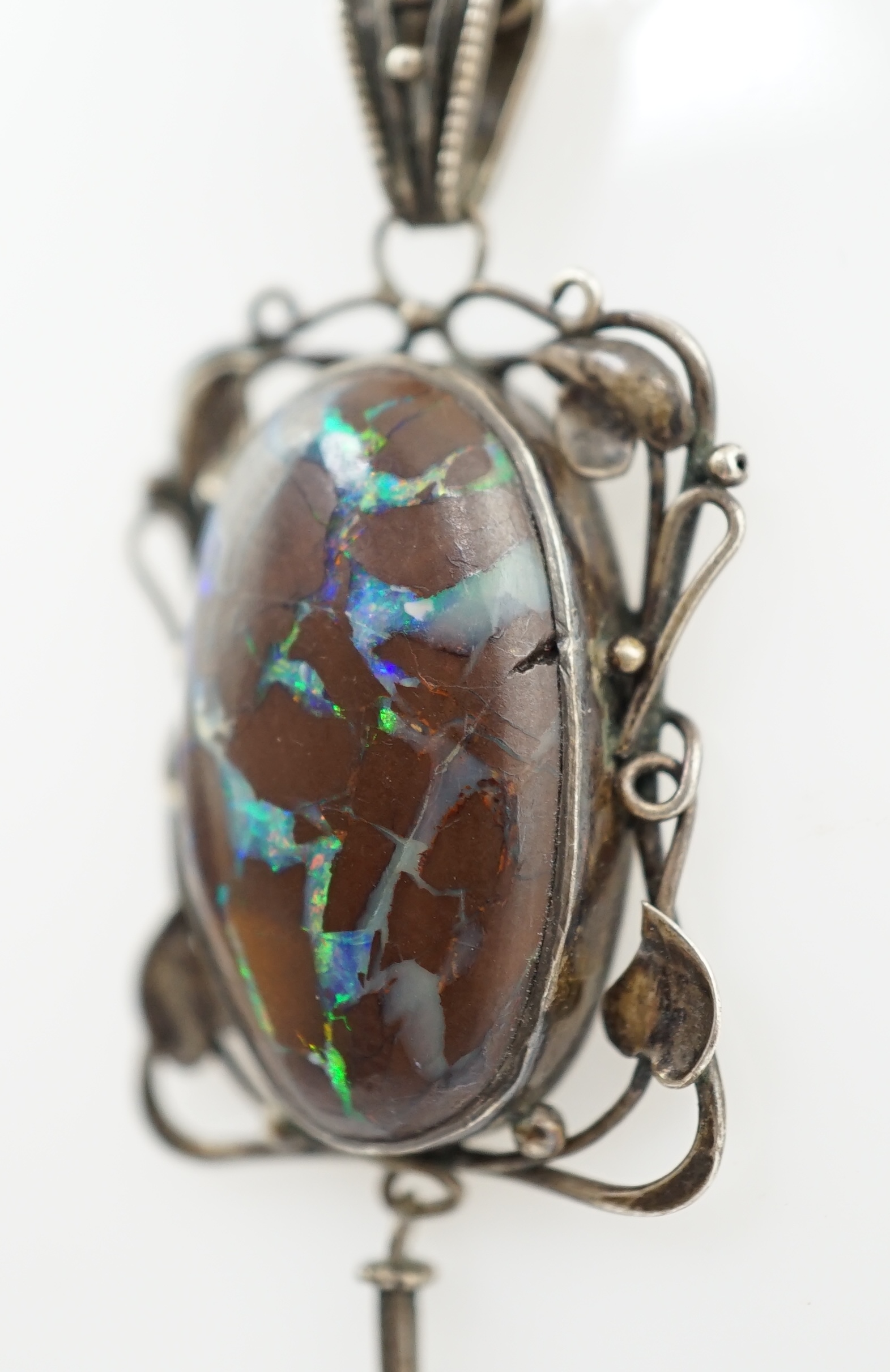 An Art Nouveau silver and oval black opal set drop pendant necklace